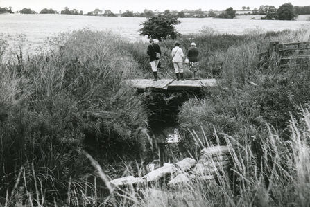 RNHS survey party standing on a footbridge over the River Gwash south-west of Brake Spinney, looking upstream. From left to right, Betty Eaton, Joan Levisohn and Dr Erica Hutton. 