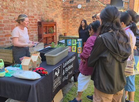 Photo of people watching a butterfly workshop, planting wildflowers